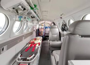 Flugzeugkabine mit Trage, grauen Sitzen und medizinischer Ausrüstung