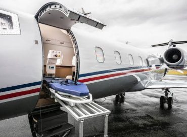 Patiententrage an der geöffneten Tür eines Ambulanzflugzeugs